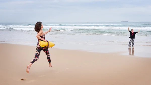 Madre fingiendo necesitar ser rescatada por su hija junto a la playa — Foto de Stock