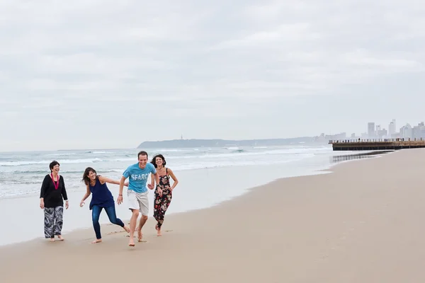 Familia siendo juguetona juntos en la playa — Foto de Stock