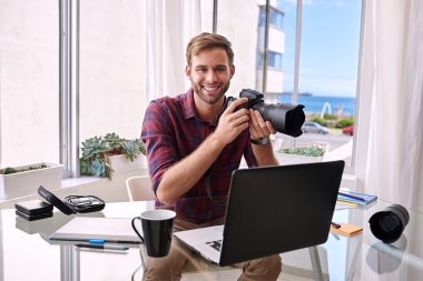 bir kamera elinde kamerayla gülümseyen genç profesyonel fotoğrafçı