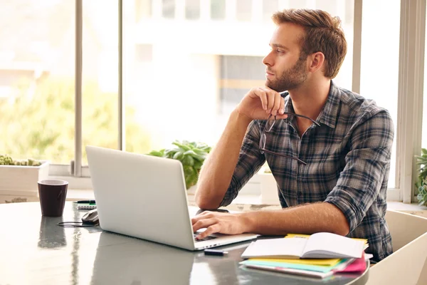 Genç girişimci düşünce pencere bakarak