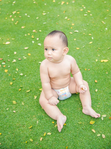 Cute baby boy sitting in the park — Stock Photo, Image