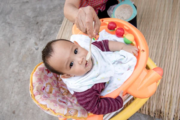 Baby eating food by spoon — Stock Photo, Image