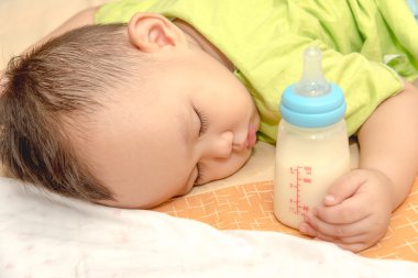 Asya bebek biberon süt Holding'in elinde uyku