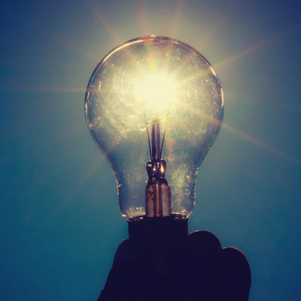 Light bulb against the sunlight with clear blue sky, concept photo of idea think and innovation