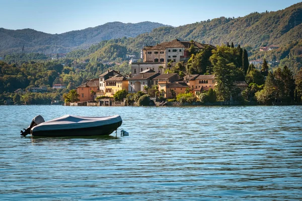 Orta Göl 'deki Orta San Giulio adası (Piedmont, Kuzey İtalya) Orta' dan göl kıyıları boyunca görülür. UNESCO Dünya Mirası Alanı, manastır rahibelerinden oluşan bir manastıra ev sahipliği yapıyor. Renkli resim.