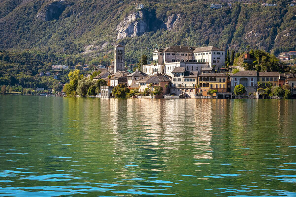 The world famous Orta San Giulio island, in the Orta Lake (piedmont, Northern Italy) seen from the city of Orta, along the lake shores. UNESCO World Heritage Site, it is home to a convent of cloistered nuns. Color image.