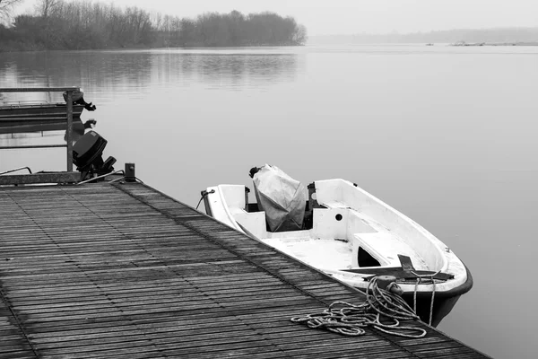 Po Fluss: Freizeit-Motorboot, das zur Erholung im Winter festgemacht hat. Schwarz-Weiß-Foto. — Stockfoto