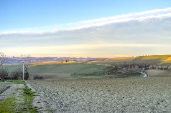 Região montanhosa de Monferrato, campo de pousio rural, nascer do sol de inverno. Imagem colorida — Fotografia de Stock