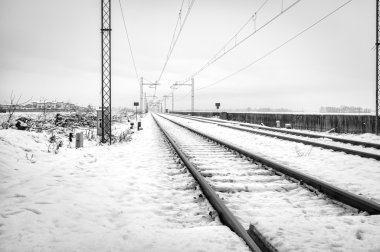 Railroad in the country, winter landscape with snow. Black and white photo clipart
