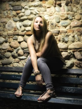 Kız bankta oturuyor.