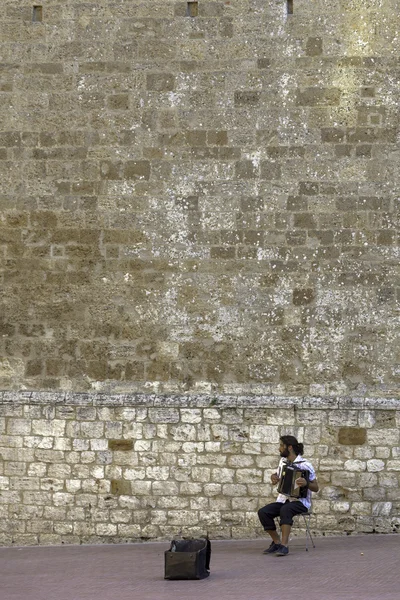 San Gimignano, Tuscany, street musician. Color image — Stock Photo, Image