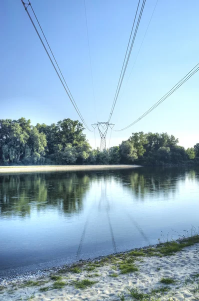 Stromleitung über einen Fluss. Farbbild — Stockfoto