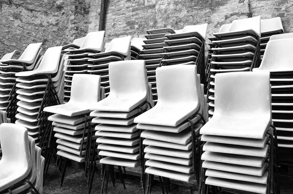 Group of stacked plastic chairs. Black and white photo — Zdjęcie stockowe