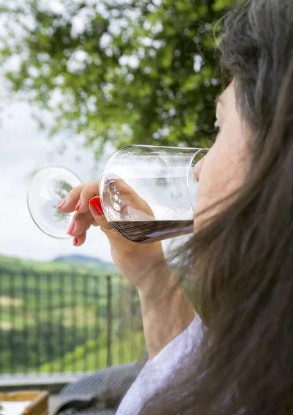 Mujer degustando una copa de vino tinto. Imagen en color — Foto de Stock