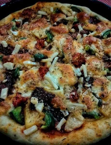 Pizzanın yakın plan fotoğrafı. Biberli çedar peynirli domates sosu çok lezzetli görünüyor.