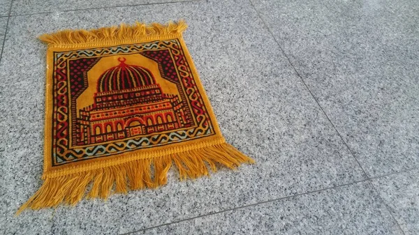 Small yellow prayer mat for Salat al-jama\'ah (congregational prayer)