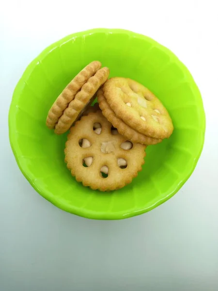 Beyaz arkaplanlı melamin tabakta yer fıstıklı bisküviler