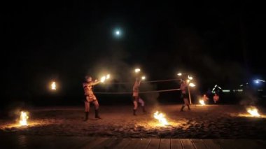 Yangın gösterisi performansı. Genç güzel kadın yangın sanatçıları Grup gece plajda alevler dönen yanan meşaleler ile dans 