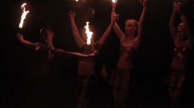 Ateş gösterisi gösterisi gösterisi. Ateşli kadın itfaiyecilerden oluşan bir grup siyah arka planda yanan meşalelerle dans ederek binlerce el Bodhisattva figürü oluşturuyor. Yavaş çekim