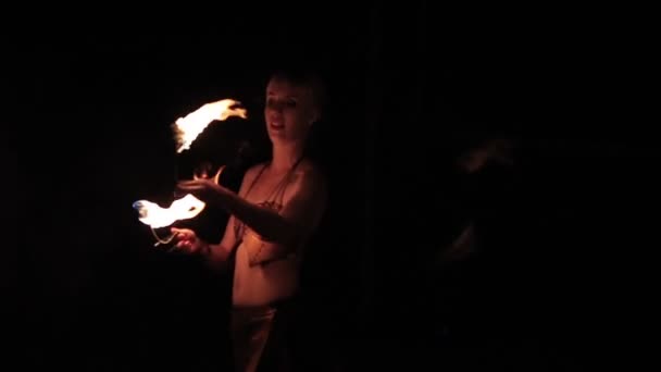 Fire show performance. Female fire performers dance with burning fire torches on a black background. Close-up. Slow motion — Stockvideo