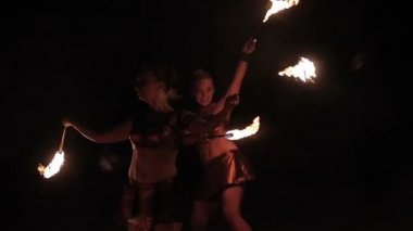 Ateş gösterisi performansını. İki seksi kadın kadın ateş ateş meşaleler siyah arka plan üzerine yanma ile performans dans. Ağır çekim