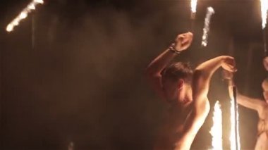 Ateş gösterisi performansını. Ateş gösterisi grup siyah arka plan üzerine twirling yangın yılanlar çevresinde dans. Yakın çekim. Ağır çekim