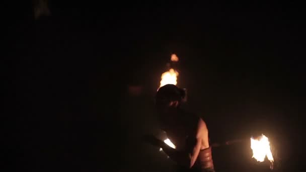Desempenho de fogo. Bonito executante de fogo masculino girando bastão de fogo inflamado de ambos os lados. Movimento lento — Vídeo de Stock