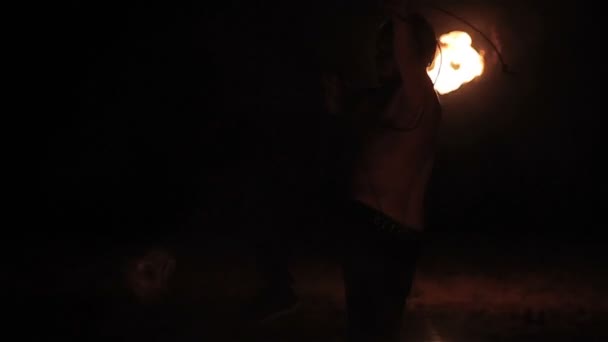 Spectacle de feu. Homme artiste de feu filature brûlant poi de fléchette de corde de feu sur une longue corde autour de lui-même. Mouvement lent — Video