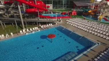 Arkadaşlar Yüzme Havuzu Açık havada hava görünümünü ağır çekimde atlamak. 3 mutlu genç erkek erkek çocuk var eğlenceli yapma takla havuzda su park dışında beyaz güneşlenme yatakları ile yaz günü - helikopter yukarı vurdu