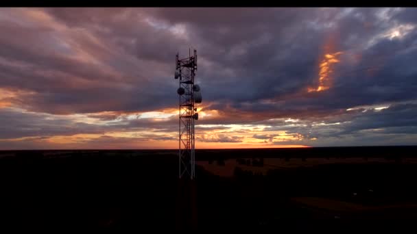 Telecommunication tower with antennas flying over 4k high-tech electronic television communications wireless technology 5g tower mast silhouette apocalyptic storm clouds dramatic sunset dusk sky — Stock Video