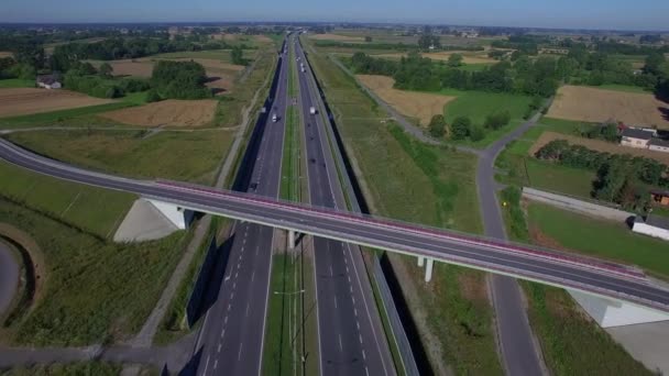 Volez au-dessus du pont supérieur à l'autoroute dans la campagne avec des voitures camions se déplaçant dans les deux sens 4K HD vue de dessus. Multiplier la circulation des véhicules à voie divisée par temps ensoleillé en Pologne Europe de l'Est 