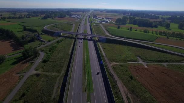 Latać przez wiadukt most na autostradzie z samochodów ciężarówki ciężarówki ruchu obu kierunkach 4k Hd. samochodów przemieszczających się na ruchu drogowym pojazdów pod most malowniczy widok z góry krajobraz Europy wschodniej Polsce — Wideo stockowe