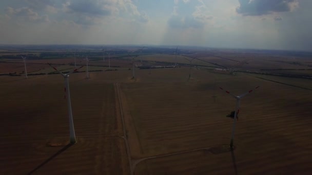 4 k Hd wiatr turbina gospodarstwa lotnicze wideo przelatują nad. Wiatraki w produkcji energii ze źródeł odnawialnych pejzaż pola dwutlenku węgla wpływ ciemnego nieba Boskiej apokaliptycznym słońcu światło w Europie Niemcy wytwarzania energii — Wideo stockowe