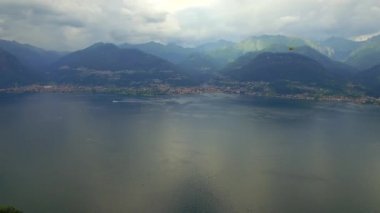 Helikopter sinek Como Gölü hava 4 k bulutlu gün boyunca kurtarma. Büyük güzel göl ve küçük pitoresk İtalyan şehir Alp dağ tepe Yukarıdaki videoyu izlemek. Lombardy İtalya Avrupa ünlü turizm
