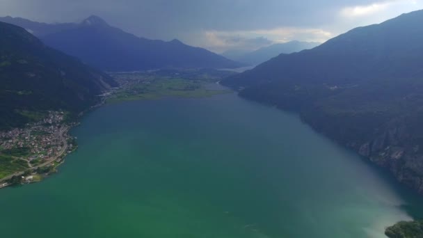 Como Lake blue water 4k aerial from above. Fly over beautiful wide lake and little picturesque Italian town at Alps mountain foot top view video. Como Lake Lombardy Italy famous tourist destinations — Stock Video