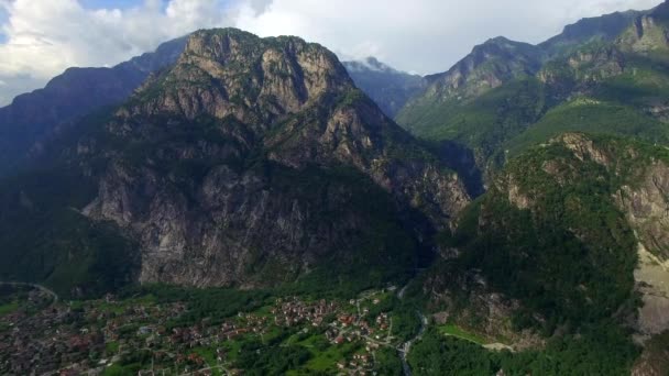 Montaña rocosa y la ciudad en el valle a pie aérea cerca del lago de Como en Italia. Vista panorámica del pueblo cerca de los verdes Alpes vista de la cima de la montaña desde arriba drone video. Destino turístico y alpinista famoso — Vídeos de Stock