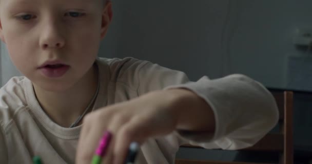 Retrato de mano detallado del niño que elige el lápiz de color para dibujar en cámara lenta. Vista frontal de cerca del niño que se prepara para hacer la tarea escolar foto enfoque selectivo dof poco profundo. Concepto educativo — Vídeos de Stock