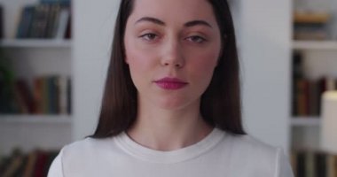 Arka planda ağır çekimde poz veren üzgün kızın yakın portresi. Ciddi bir ifadeyle kameraya bakan düşünceli kadının vesikalığı. Cilt makyajı ruj konseptini oluşturur. Sorunlar çözülüyor 