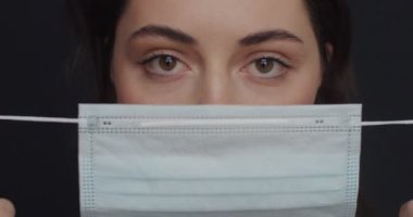 Ofiste doktor yüzü maskesi takan güzel bir kadın portresi. Genç kadın Covid-19 pandemik koronavirüs karantinasında koruyucu maske takıyor. Tıp hastalıkları konsepti.