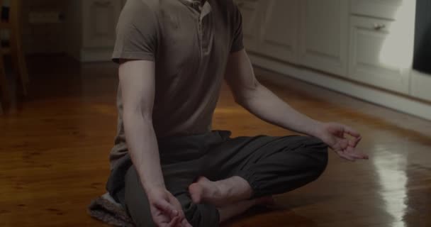 Tranquillo uomo meditando in loto posa da solo a casa sfondo rallentatore. Ritratto di uomo d'affari freelance che pratica yoga per rilassare sollievo colpo scorrevole. Meditazione concetto di concentrazione benessere — Video Stock