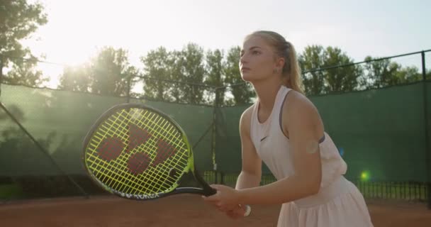 年轻迷人的女运动员站在球场上接受网球慢动作.适合网球选手手握球拍参加比赛的前视镜.体育设备保健 — 图库视频影像