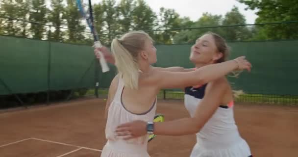 Şampiyonluk maçından önce kortta kucaklaşan birkaç mutlu tenisçi. Genç bayan arkadaşlar turnuva sırasında kucaklaşıyorlar. Dostluk sporu sağlık yaşam tarzı — Stok video