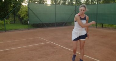 Üzgün kadın, tenis maçını kaybettiği için acı içinde raket fırlatıyor. Kız oyuncunun düşük açılı portresi. Maç kaybedeni üzgün hissediyor. Duygular dayanıklılığa dayanır. 