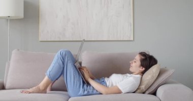 Bilgisayar kopyalama boşluğunda ödev yapan kız öğrencinin yan görüntüsü. Mutlu kadın not defteri kullanarak arkadaşlarıyla ağır çekimde iletişim kuruyor. Uzaktan çalışma ev eğitimi boş zamanı