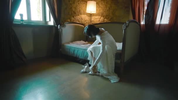 Bride puts on her shoes in a beautiful antique interior — Stock Video