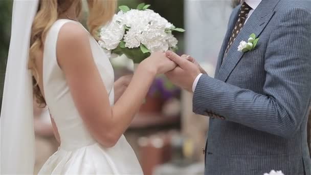 Lo sposo mette una fede nuziale al dito di una sposa. Sposa mette un anello al dito di un — Video Stock