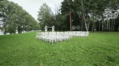 Açık hava düğün töreni için hazır çim sandalye satırı. Steadicam