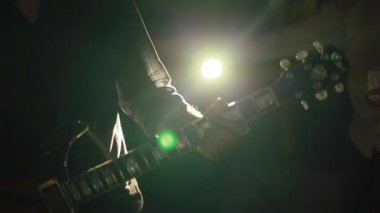 Müzisyen bir güzel renkli arka ışık Club gitar çalmak. Yakın çekim