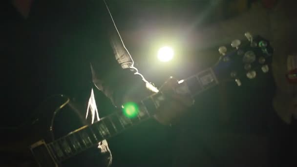 Музыкант играет на гитаре в клубе в красивой красочной подсветке. Крупный план — стоковое видео