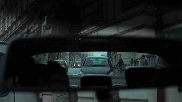 Rétroviseur reflet de la rue du soir avec bâtiments voitures et passants — Video